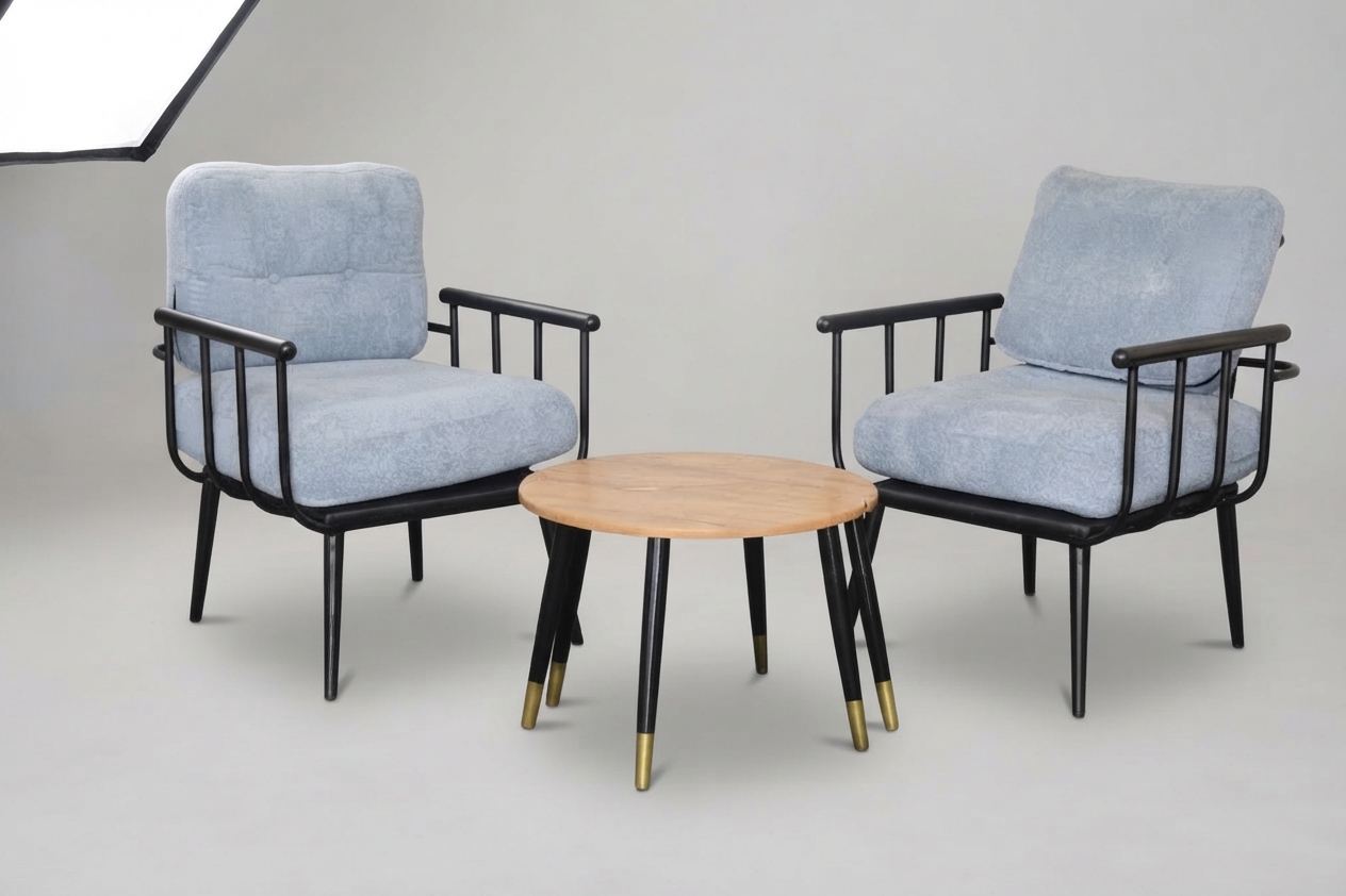Two grey upholstered armchairs with a round wooden table